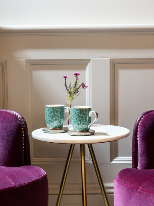 Two mugs and two sofas in the Evewell Clinic waiting room