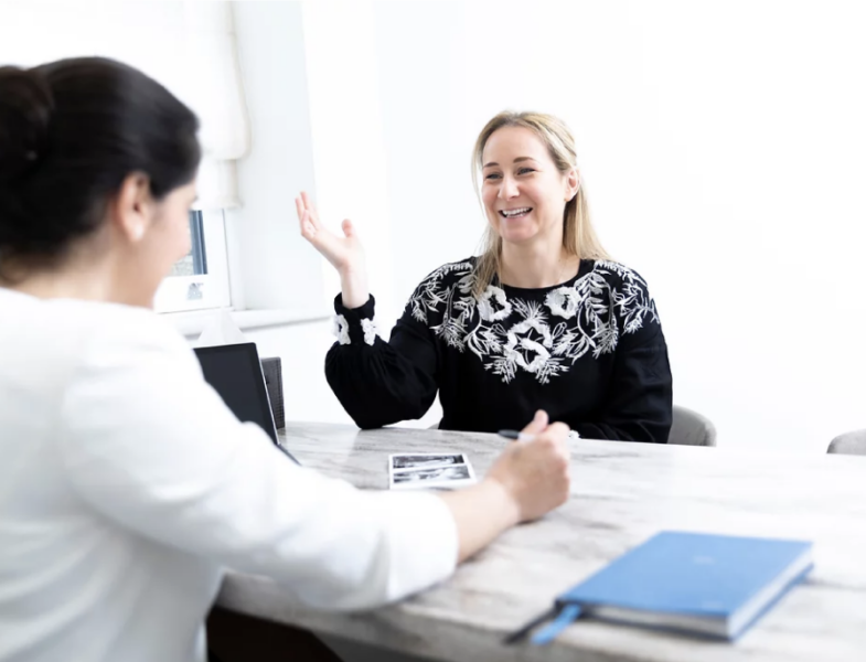 Consultant and patient sitting at a desk discussing PCOS and treatment options