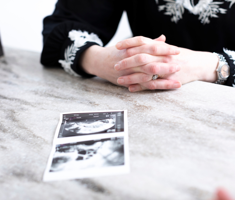 Patient with her ultrasound pictures in front of her on a desk