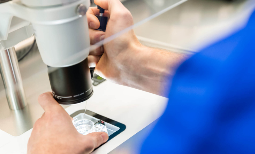 Picture of equipment in a fertility laboratory with an embryologist doing PGT A testing