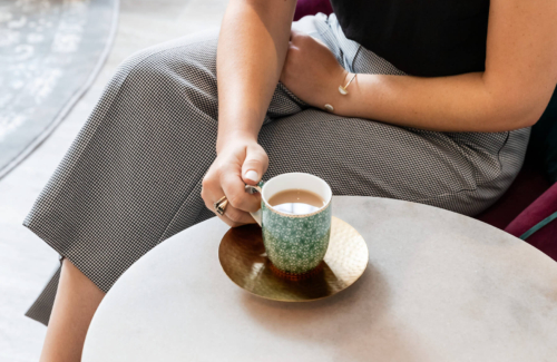 a woman sitting at a chair with a cup of tea discussing she needs help getting pregnant