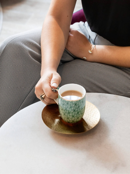 a woman sitting at a chair with a cup of tea discussing she needs help getting pregnant