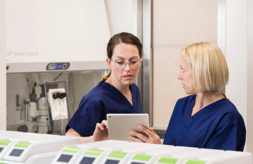 Two embryologists in the laboratory discussing samples on an ipad