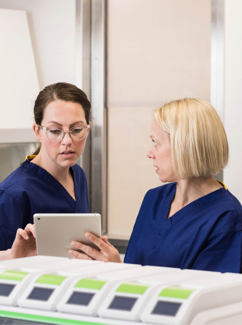 Two embryologists in the laboratory discussing samples on an ipad