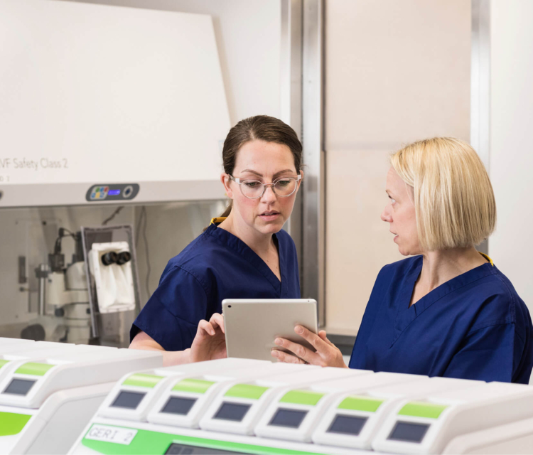 Two embryologists in the laboratory discussing samples on an ipad