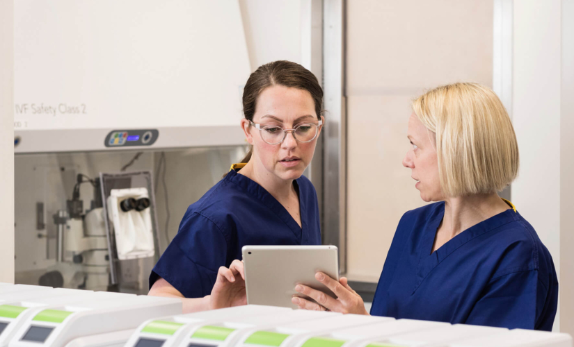 Two embryologists in the laboratory discussing samples on an ipad