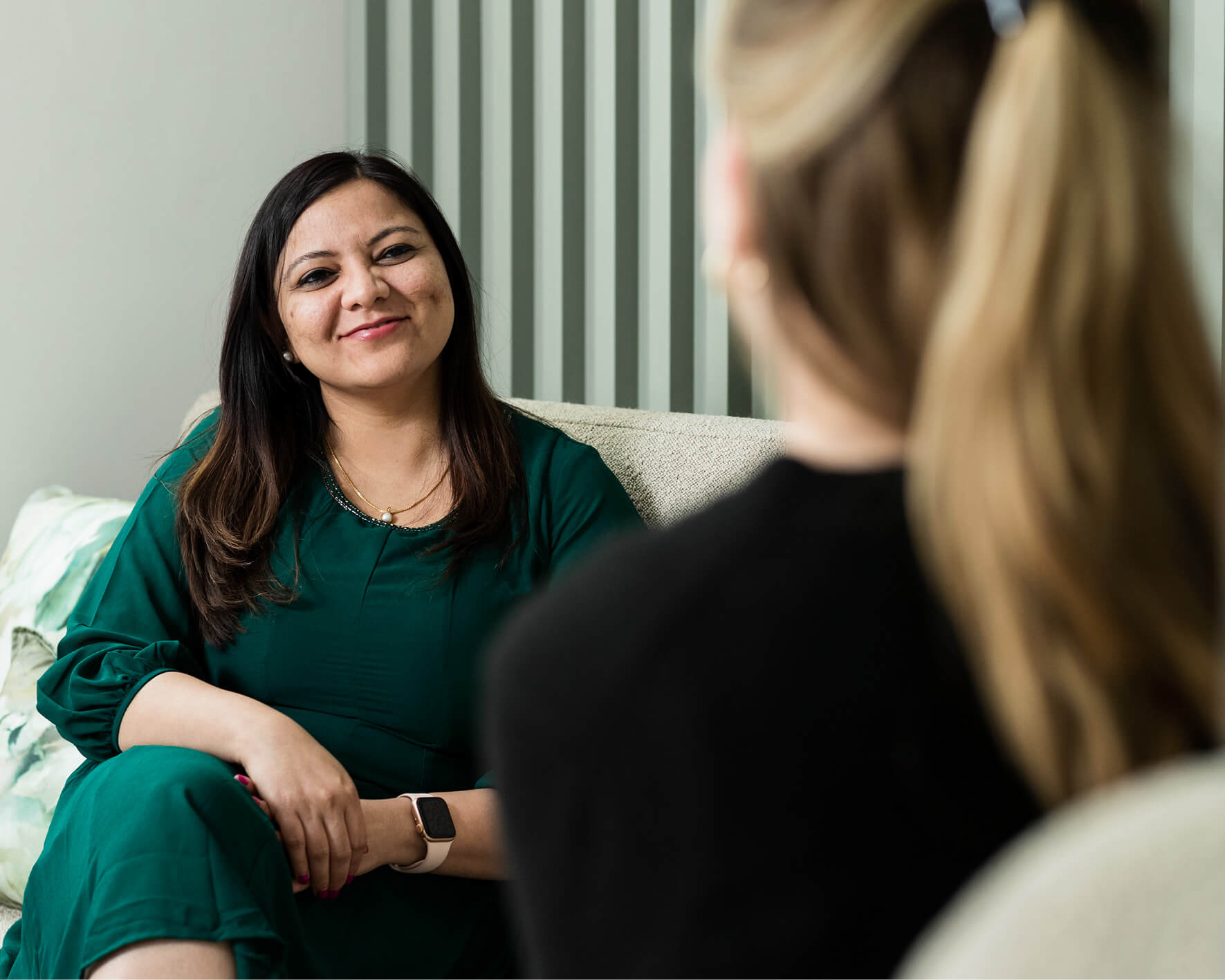 Image of a female consultant sitting on a chair talking to a female patient about PGT-A testing options