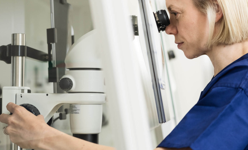 Embryologist in the fertility lab looking at fertility samples through a microscope