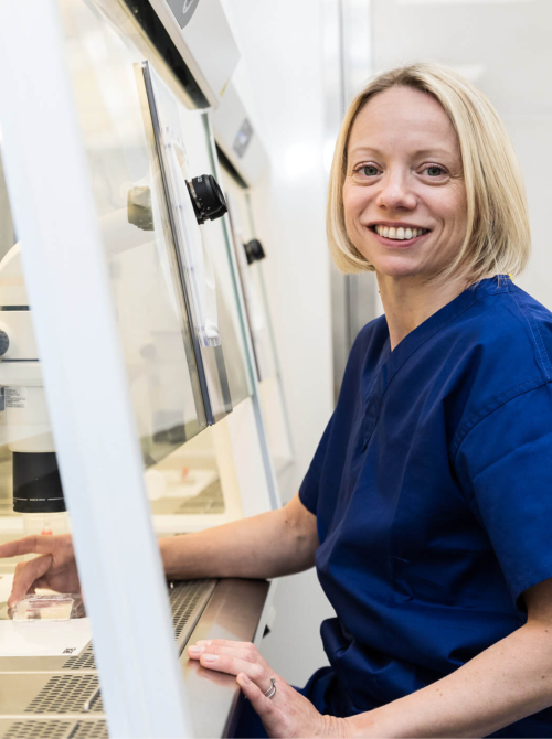 Embryologist sitting in her lab looking at fertility samples and embryo freezing