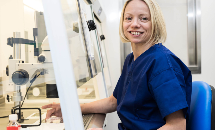 Embryologist sitting in her lab looking at fertility samples and embryo freezing