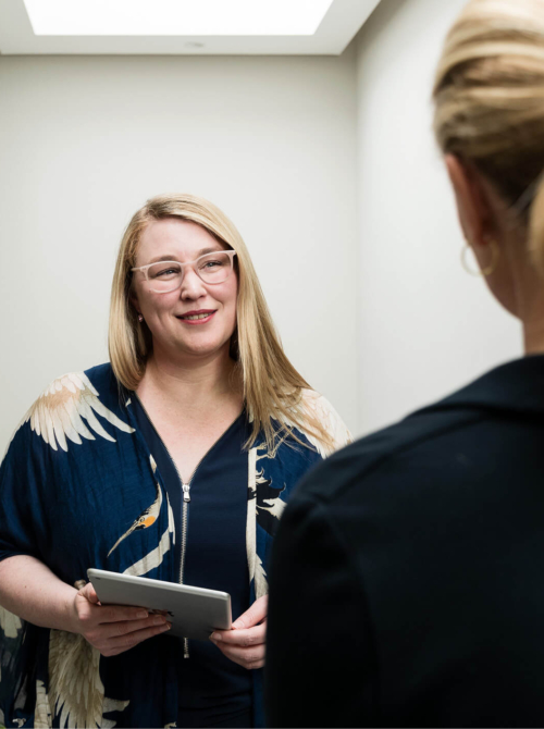 Image of a consultant talking to another woman in a hallway about infertility