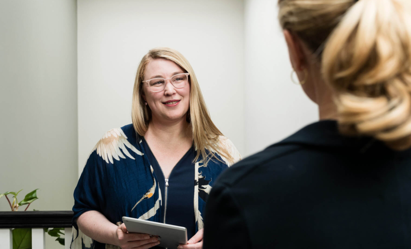 Image of a consultant talking to another woman in a hallway about infertility