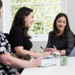 The patient services team sitting together discussing fertility pricing and IVF costs