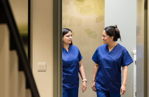 Two fertility nurses chatting and walking around the Evewell Clinic