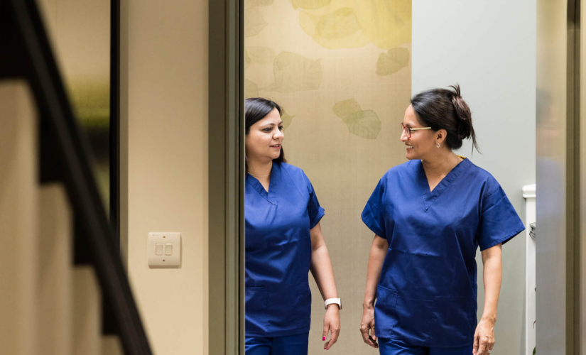 Two fertility nurses chatting and walking around the Evewell Clinic