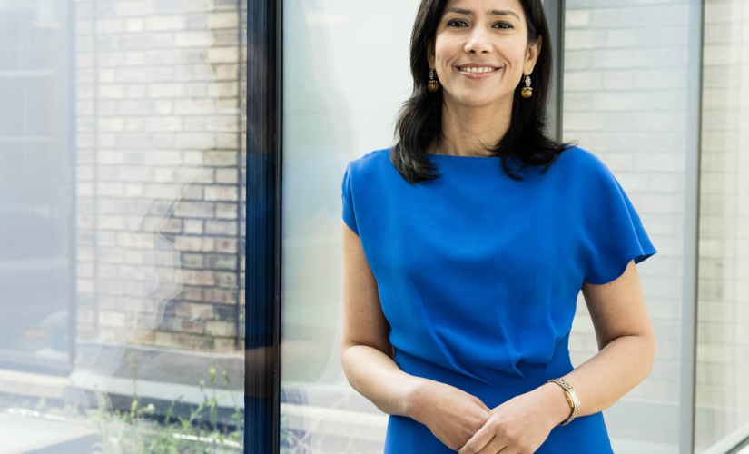 A consultant standing by the window with her hands together