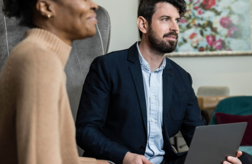 Lab director and fertility consultant sitting together looking at a patient discussing male infertility