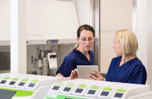 Two embryologists in the laboratory discussing the results of PGT A testing on their ipad