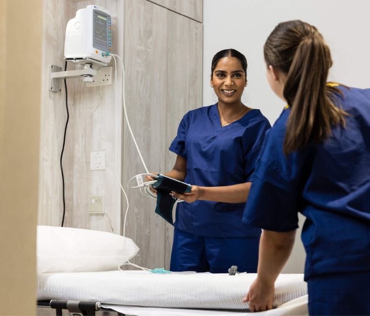 Two female nurses in scrubs discussing HyCoSy and treament